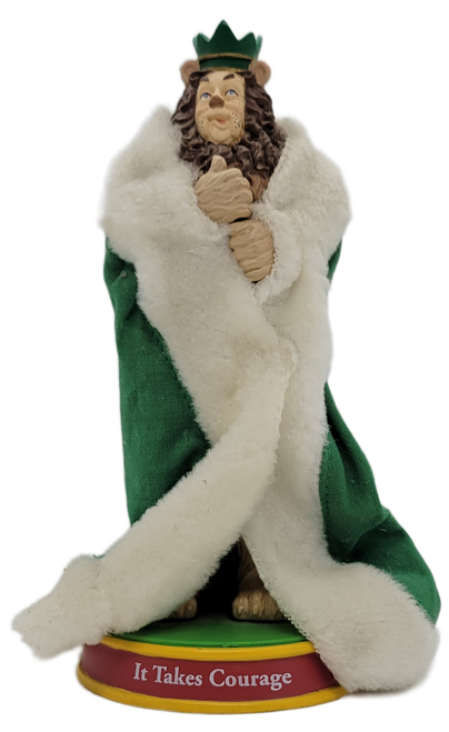 VANDOR 2000 Cowardly Lion "It Takes Courage" bobble figure from The Wizard of Oz.  The Cowardly Lion stands 7-inches tall and is wearing a green robe with white trim and green crown.  He is standing on a base that has "It Takes Courage" on it.