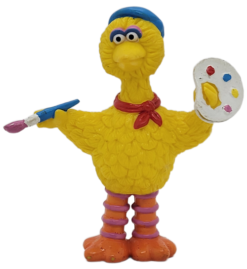 Sesame Street PVC toy figure of Big Bird painting by Applause. Big Bird is holding a blue paint brush in right hand and a paint pallet in the left hand.  The figure stands 3.75 inches tall.