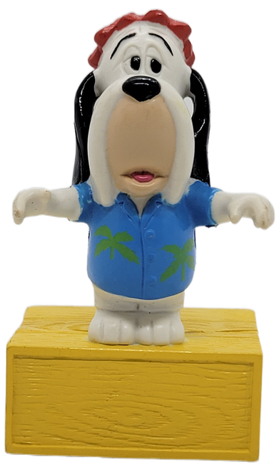 McDonald's Happy Meal toy of Droopy from the 1990 Tom and Jerry Band series of toys.  Droopy is wearing a blue shirt with green leaves and is standing on a platform.  The series of toys from the Tom & Jerry Band was available September 2-October 4, 1990.