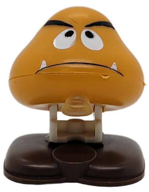 Nintendo 1989 Super Mario Bros Goomba 2-inch Figure (Loose), a small yellow figurine of a Goomba character from Super Mario Bros with a sad facial expression.