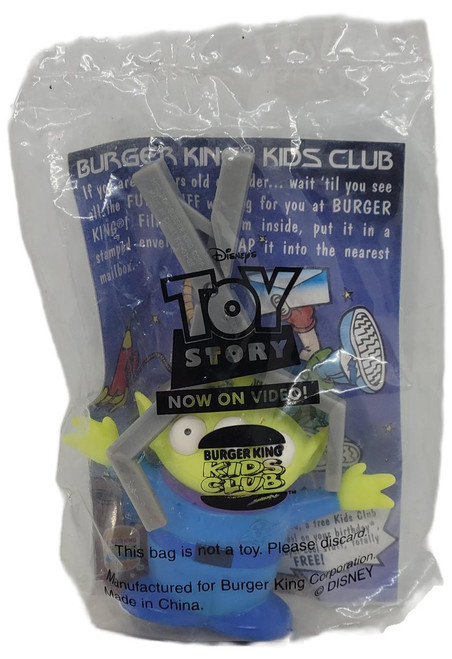 Burger King Kids Club 1996 Disney's Toy Story The Squeeze Toy Alien Figure, a small green alien toy with one eye and a black mouth, inside its original plastic packaging.