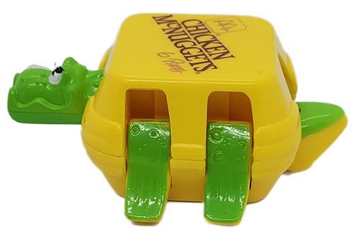McDonald's Happy Meal toy of McNuggets-O-Saurus from the 1991 McDino Changeables series.  The McNuggets-O-Saurus looks like a Chicken McNuggets container and transforms into a green dinosaur.