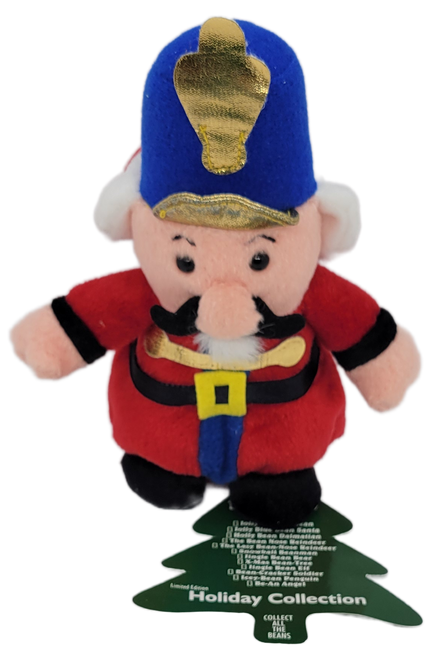 Stuffins 1997 Lumpy's Bean Bag Gang Bean-Cracker Soldier limited edition Holiday Collection. Bean-Cracker Soldier is wearing a red suit and carrying a blue hat. The Holiday collection can also be used as a ornament.