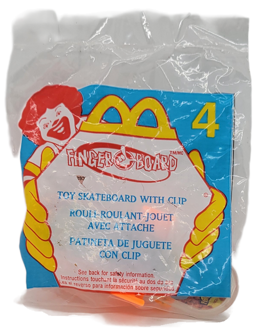 McDonald's Happy Meal toy of a toy skateboard with clip from the 2000 Finger Board series of toys. The orange with clear plastic skateboard comes with orange clip. The series contains 8 different skateboard themed toys.