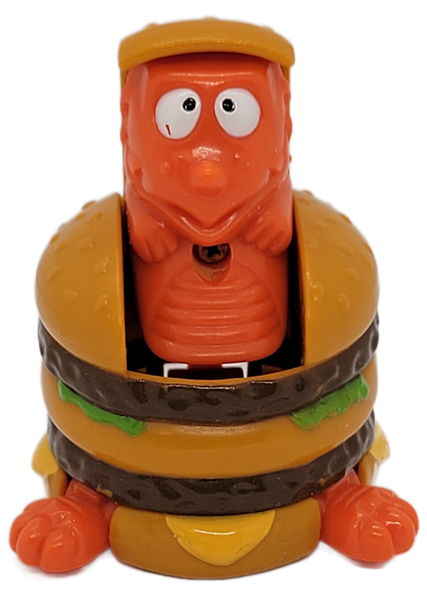 McDonald's Happy Meal Toy of Big Mac-O-Saurus Rex from the 1991 McDino Changeables series of toys. Big Mac-O-Saurus Rex is a Big Mac that transforms into a orange dinosaur. The series contains 10 different McDonald's foods that transform into dinosaurs and was available May 24-June 20, 1991.