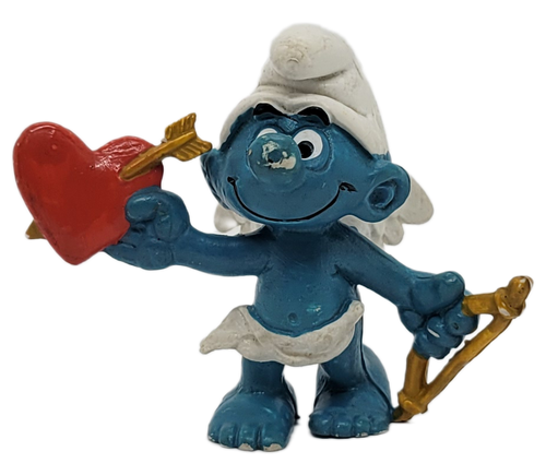 2.0128 Amour Smurf variation with thin orange bow, with Schleich and Peyo and Made in Hong Kong for ages 3 & up. Happy Valentine's Day! This little cupid carries a big red heart with an arrow through it and a bow in the other hand. Love is in the air! 20128 Amour Smurf PVC Figure. From 1980.
