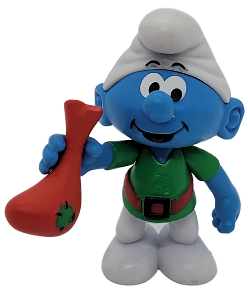 Jakks Pacific 2009 Elf Jokey Smurf figure holding a red stockings from The Smurfs Holiday Gift Pack. Jokey Smurf is wearing a green shirt with red belt and stands 2.25-inches tall. The set is recommended for ages 4 & up and was made in China.