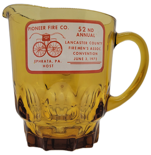 52nd Annual Lancaster County Firemen's Association Convention that was held June 3, 1972 in Ephrata, PA and celebrated by the Pioneer Fire Company amber glass pitcher. The one side has the convention information and an antique pump cart with Ephrata 1867 on it. The opposite side has firemen with "Ever Alert" on top and since 1889 under him.
