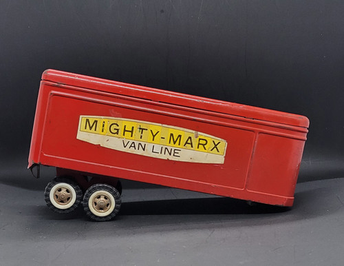 Vintage Mighty-Marx van line pressed steel trailer by Marx. The trailer is red with Mighty-Marx Van Line on each side and white swing doors on the trailer. The trailer is 9-inches long and has plastic wheels and was Made in Japan.