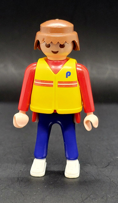 Geobra the German manufacture of Playmobil 1992 Headphone wearing Crew Member from 3091 Formula One Pit Crew Team 3-inch tall figure for ages 3+. The figure is wearing a red shirt with yellow jacket and blue pants. The crew member is missing his hat and headphones.