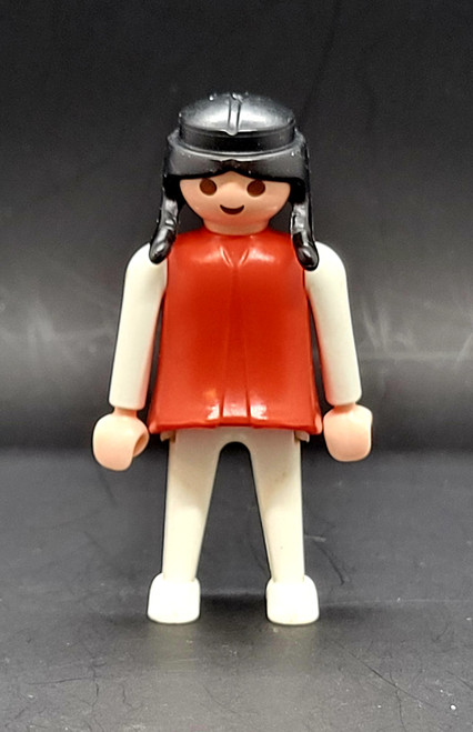Geobra the German manufacture of Playmobil 1974 female Indian 3-inch tall figure for ages 4+. The figure is wearing a red top and white shirt and pants. The figure is missing headpiece.