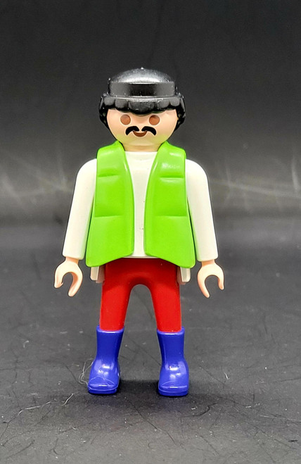 Playmobil GEOBRA PLAYMOBIL 1992 Male With White Shirt Green Vest 3" Figure, front view of a vintage mustached Playmobil figure wearing a black hat, white shirt, bright green vest, red trousers, and blue boots.