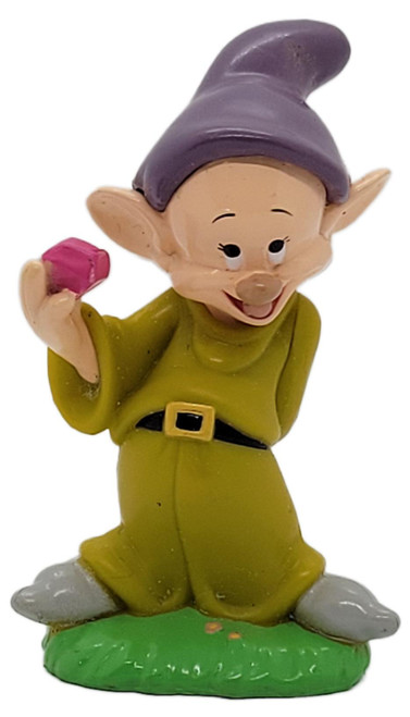 Disney Snow White and the Seven Dwarfs Dopey 2.5" PVC Figure, smiling Dopey figure wearing a purple hat and green outfit, holding a pink gem while standing on a green base