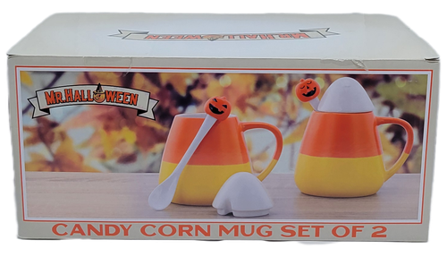 The Mr. Halloween Candy Corn Mug Set features two ceramic, candy corn-striped mugs complete with matching lids and pumpkin-topped spoons. Shaped and colored like classic candy corn with orange, yellow, and white tiers, accented by ceramic lids and matching stirring spoons featuring smiling jack-o'-lantern toppers. A set of two mugs, two lids, and two spoons packaged together in a seasonal display box.