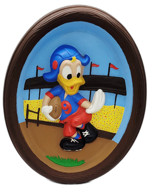 Vintage 12-inch Walt Disney Production 3-D wall plaque featuring Donald Duck playing football. The hand painted plaster plaque has Donald Duck wearing red pants, blue with red jersey running football. The frame is brown with wood texture that is 1-inch deep.
