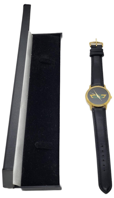 Ward Truckload Express Vintage Ward Truckload Express Corporate Logo Watch – Gold Tone & Black Leather, gold-tone wristwatch with a black logo dial and black leather strap displayed beside an open black presentation box.