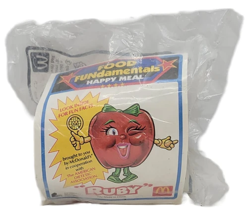 McDonald's Happy Meal Toys 1993 Food FUNdamentals Ruby The Apple, vintage sealed toy package featuring a smiling red apple character on the illustrated label.
