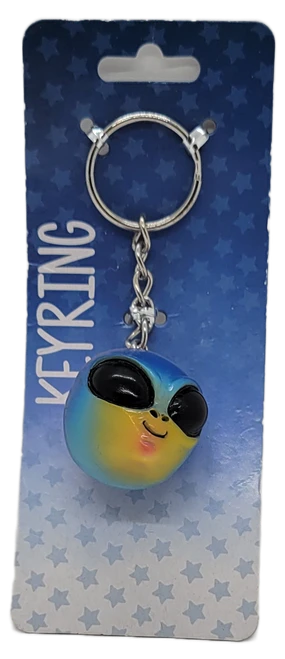 Colorful smiling alien head keyring with large black eyes on a blue Kalan display card.