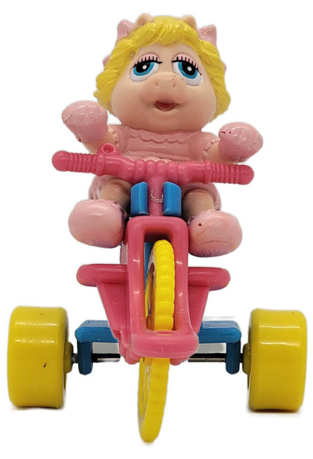 McDonald's Happy Meal Toy 1991 Muppet Babies Baby Miss Piggy (Loose), vintage pink-and-yellow tricycle toy featuring Baby Miss Piggy with blonde hair and blue eyes, photographed against a white background.