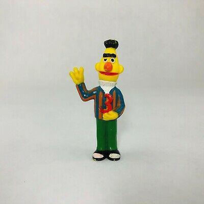 Sesame Street Applause Sesame Street PVC Bert Holding a 3 Toy Figure, colorful toy figure of Bert from Sesame Street with bright colors and playful design.