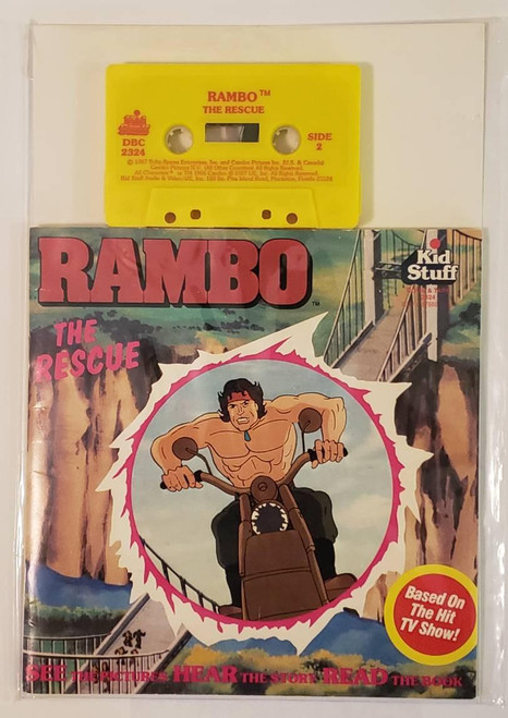 Kid Stuff Rambo The Rescue Book and Tape Set, yellow cassette tape with red and black text and graphic, and colorful illustrated book cover featuring a muscular man riding a motorcycle, based on the hit TV show.