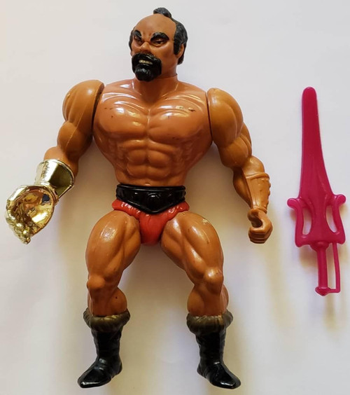 Mattel Toys Masters of the Universe - Jitsu (Loose) 1984 Mattel Action Figure Toy, action figure with muscular build, black hair, beard, and red shorts, accompanied by a pink weapon.