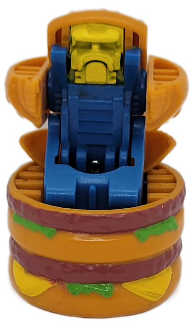 McDonald's Happy Meal Toy of Big Mac from the 1987 McDonald's Changeables series of toys. The Big Mac opens up and reveals a blue robot with yellow face. The series contains 6 different McDonald's foods that transform into robots. McDonald's offered the series to appeal to the Transformers popularity.