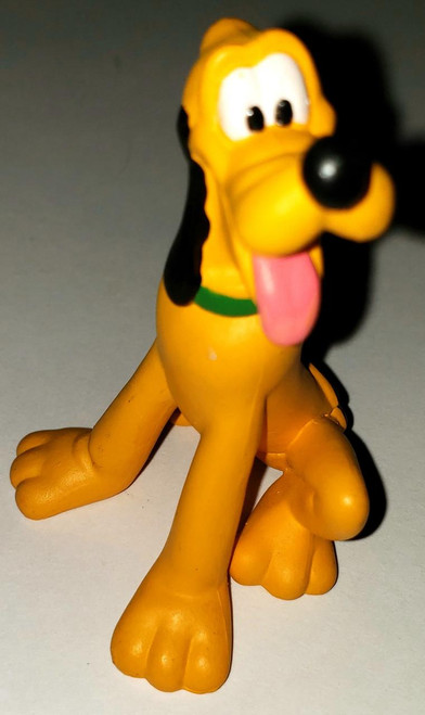 Disney Pluto 2.5" PVC Toy Figure, cartoon-style yellow dog with floppy ears, large black nose, sticking out pink tongue, green collar, standing on a gray surface.