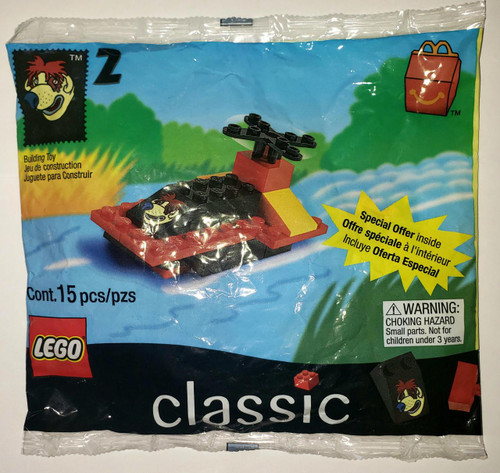Lego McDonald's Happy Meals - 1999 LEGO #2 Boat Building Toy Set, a small plastic building block toy set featuring a boat and a small yellow slide, with a colorful background of a sky and clouds.