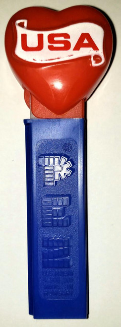 PEZ USA Red Heart Pez Dispenser, red heart-shaped top with 'USA' written on it, attached to a blue rectangular body featuring the PEZ logo.