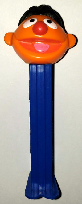 PEZ - Sesame Street Ernie Dispenser (Loose), plastic character dispenser featuring Ernie's head with black hair, orange face, big white eyes, red nose, and pink mouth, mounted on a blue PEZ candy dispensing stem.