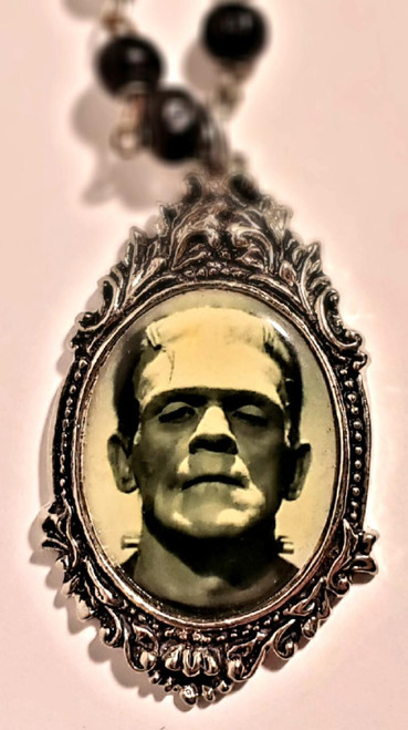 Rock Rebel Universal Monsters Frankenstein Pendant with Necklace, vintage-style Frankenstein portrait pendant with ornate frame and black beaded necklace.
