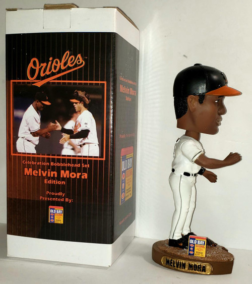 MLB 2006 BD&A MLB Baltimore Orioles Melvin Mora Bobble-head, a collectible sports figurine of Melvin Mora in a white baseball uniform and black cap with an orange brim, standing on a base with his name engraved.