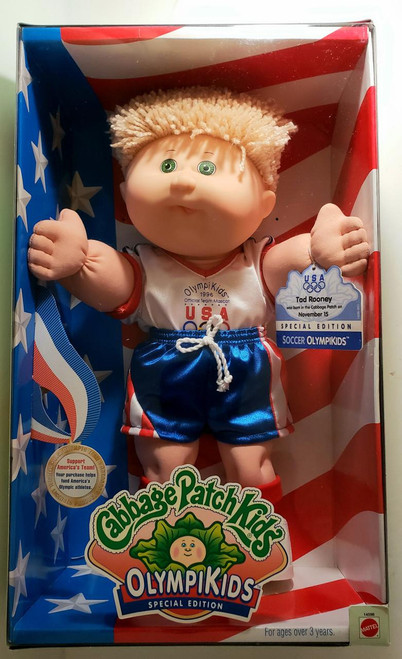 Cabbage Patch Kids 1996 Cabbage Patch Kids Olympikids - Soccer Boy, plush doll dressed in soccer uniform with American flag-themed shorts and a blond plush hair, inside packaging with patriotic and Olympic logos.