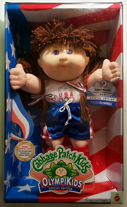 Cabbage Patch Kids 1996 Cabbage Patch Kids Olympikids - Soccer Girl, plush doll with brown yarn hair wearing an USA Olympic uniform in a box.