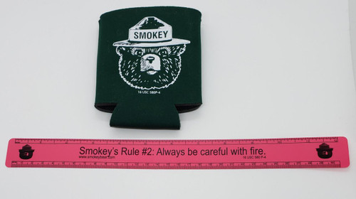 Smokey the Bear Plastic Ruler and Can Koozie, the ruler features Smokey the Bear's face and a humorous fire safety quote, with a green can koozie branded with Smokey the Bear.