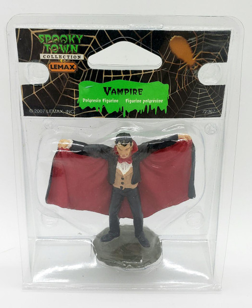 Lemax Spooky Town Vampire #72367, vampire figurine with a black suit, red cape, and black hair, standing on a round base.
