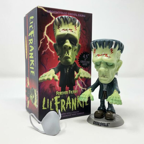 Retro-a-go-go! Forever Filthy Lil' Frankie Tiny Terror, a green zombie figurine with a grotesque appearance, wearing a black suit and standing on a Ghoulsville base, with its packaging showing a lightning background and the character in a similar pose.