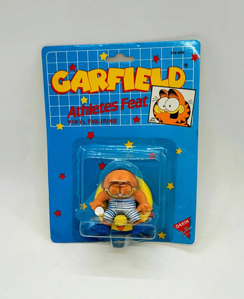 Garfield Athletes Feat Vinyl Figure, a collectible cartoon character figure of Garfield dressed as a sailor with sunglasses, sitting on a yellow duck in its packaging.