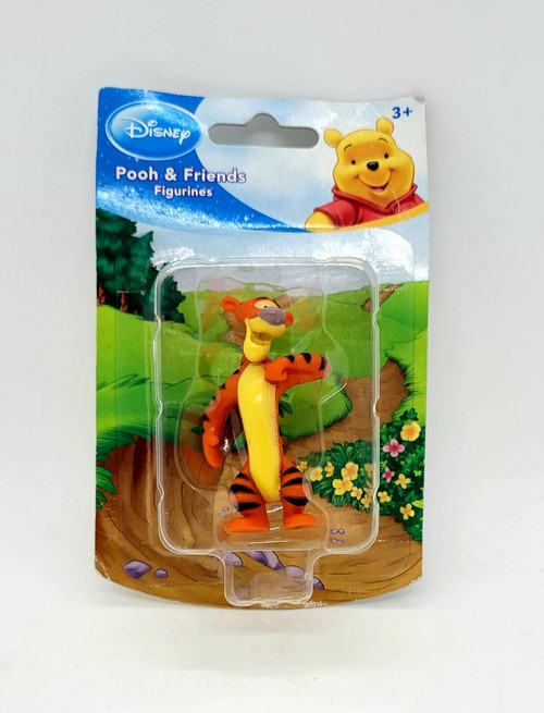 Disney Pooh & Friends Figurines - Tigger, plastic Tigger figurine from Winnie the Pooh with orange and black stripes, cheerful expression, in packaging with colorful forest background and Pooh's face at top right.
