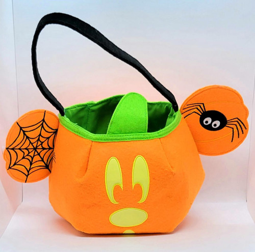 Disney Mickey Mouse Halloween Trick or Treat Fabric Bucket, orange pumpkin-shaped fabric bucket with a black handle, featuring Mickey Mouse's face, spider and web decorations, and a spider hanging from one ear for trick-or-treating.