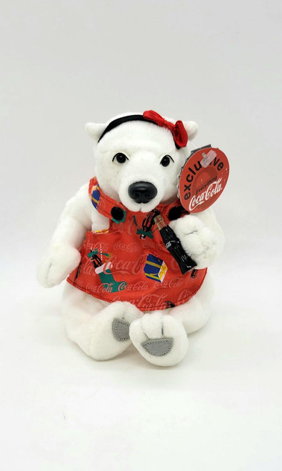 Coca-Cola 1999 Coca-Cola Female Polar Bear 5-inch Bean Bag Plush, a white plush polar bear wearing a red Coca-Cola themed dress and accessories with a Coca-Cola-themed tag.
