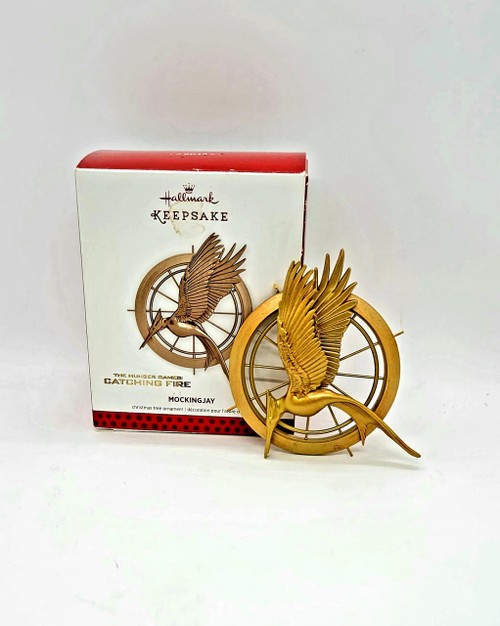Hallmark Keepsake Ornament: The Hunger Games Catching Fire - Mocking Jay, gold-colored detailed Mockingjay bird ornament with a clock face in the background.