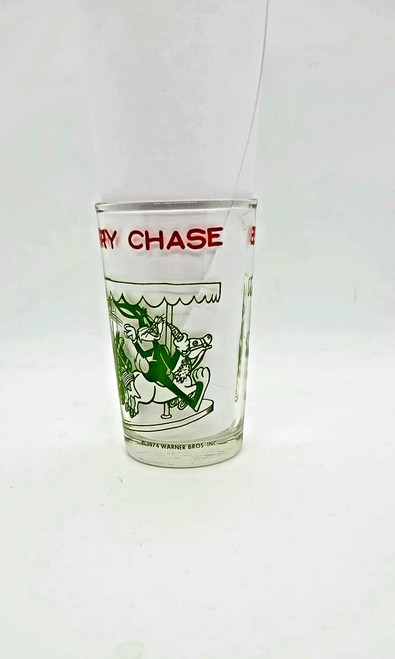Warner Bros. Bugs Bunny Leads A Merry Chase Glass, vintage cartoon character glass with a Bugs Bunny design and a red 'Merry Chase' title, collectible Warner Bros. merchandise from 1974.