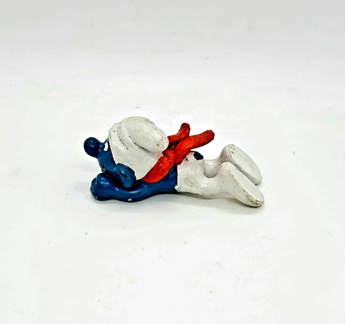 Smurfs Vintage PEYO 4.0201 Bobsled Smurf PVC Figure, depicting a colorful, vintage plastic figurine of a Smurf bobsledder with blue, white, and red colors, lying flat on a white background.