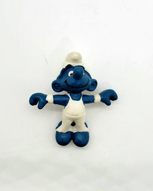 Smurfs Vintage Schleich 4.0510 Rings Gymnast Smurf PVC Figure, vintage blue Smurf toy with a white hat and outfit, standing on a plain white background.