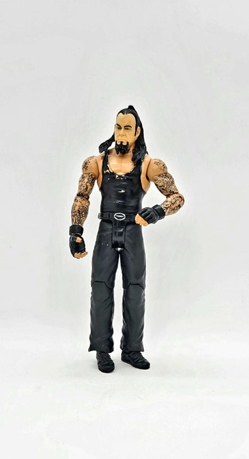 WWE 2011 Undertaker Action Figure (Loose), detailed collectible action figure with black outfit, tattooed arms, and long black hair, standing upright on a white background.