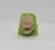 Jurassic Park Tyrannosaurus Rex Head Candy Dispenser, toy dinosaur head with open mouth and detailed features on a green base.
