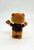 Snickers Flocked Bear with Arms Open, a chocolate plush toy with brown fur and a black shirt with blue trim, standing with arms open against a plain white background.