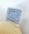 Eden Toys Beatrix Potter Peter Rabbit Benjamin Bunny Stuffed Animal, close-up of the care label with blue text on white fabric.